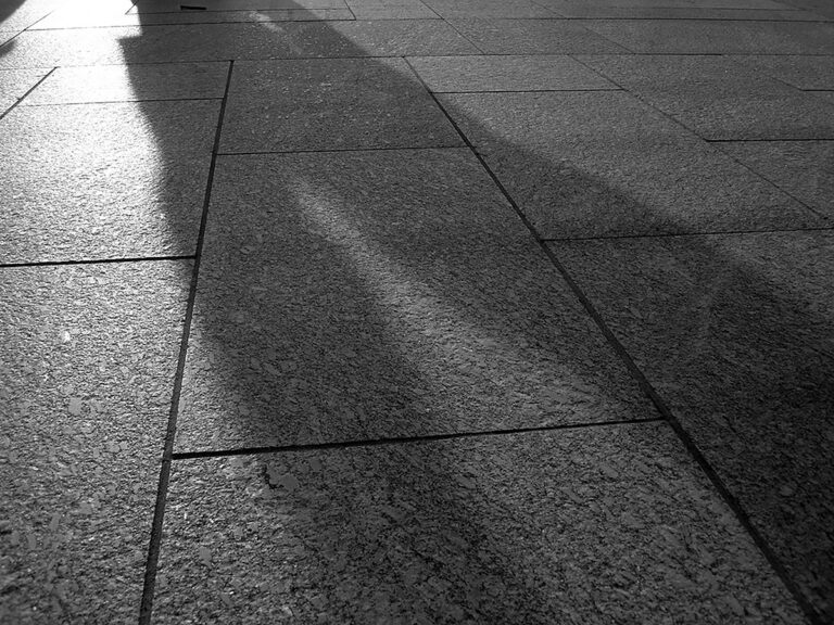 High-contrast black and white photography featuring striking geometric shadows and minimalist architectural elements by Visuals for Vigil.